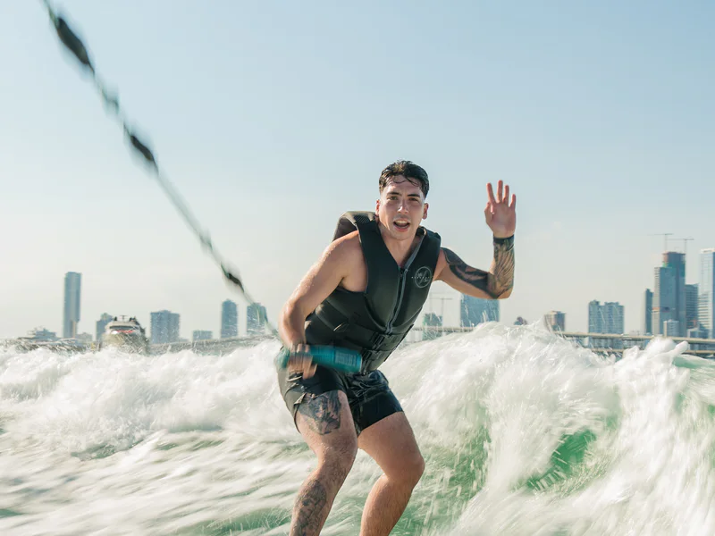 Wakesurfer riding with the Miami skyline behind him